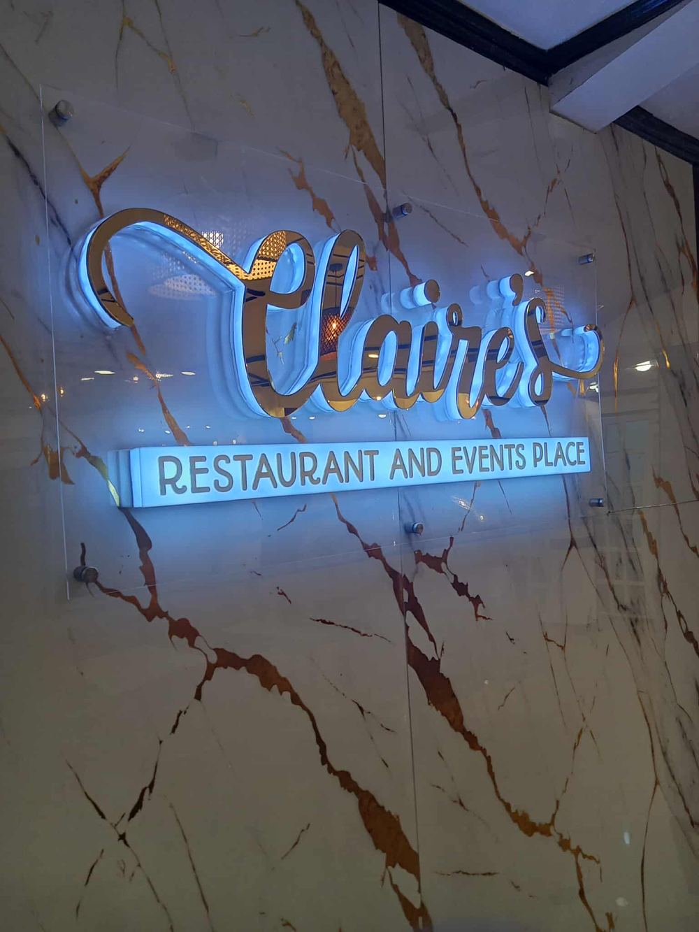 Claire's Restaurant, back-lit gold acrylic sign on marble