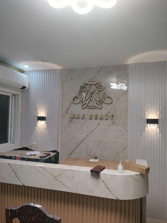 Max Beauty gold logo on a reception wall